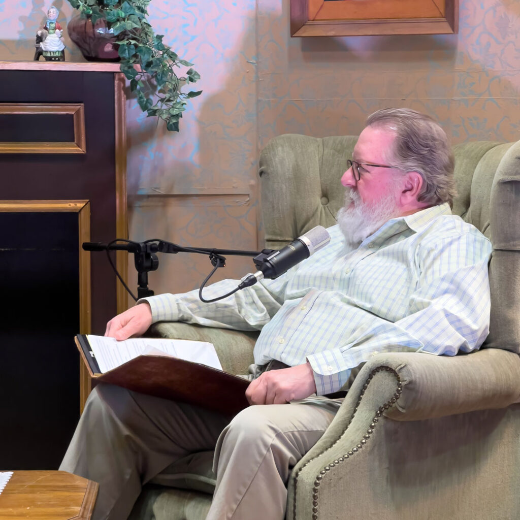 Charlie Johnson speaks into a microphone while recording the Thoughtful Connections memory care podcast.