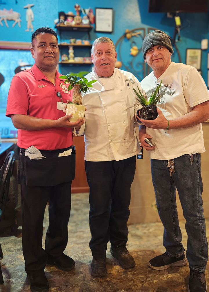 Culinary Director at Boulevard Senior Living of Wentzville presents gifted plants to local business owners.